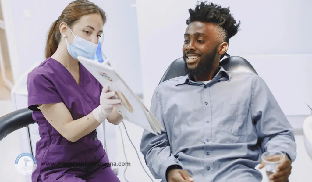 Dentist discussing dental treatments and oral cancer risks with a patient during a checkup.